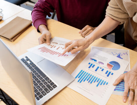 Hands of contemporary mature female broker pointing at one of financial papers Hands of contemporary mature female broker pointing at one of financial papers